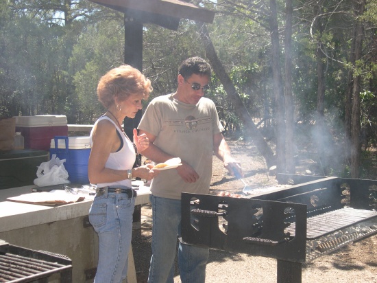 Alex tends the grill while Patti supervises